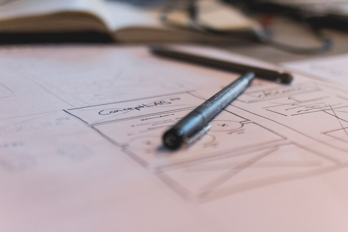 Storyboard sketches and a laptop with a video timeline open, spread across a desk