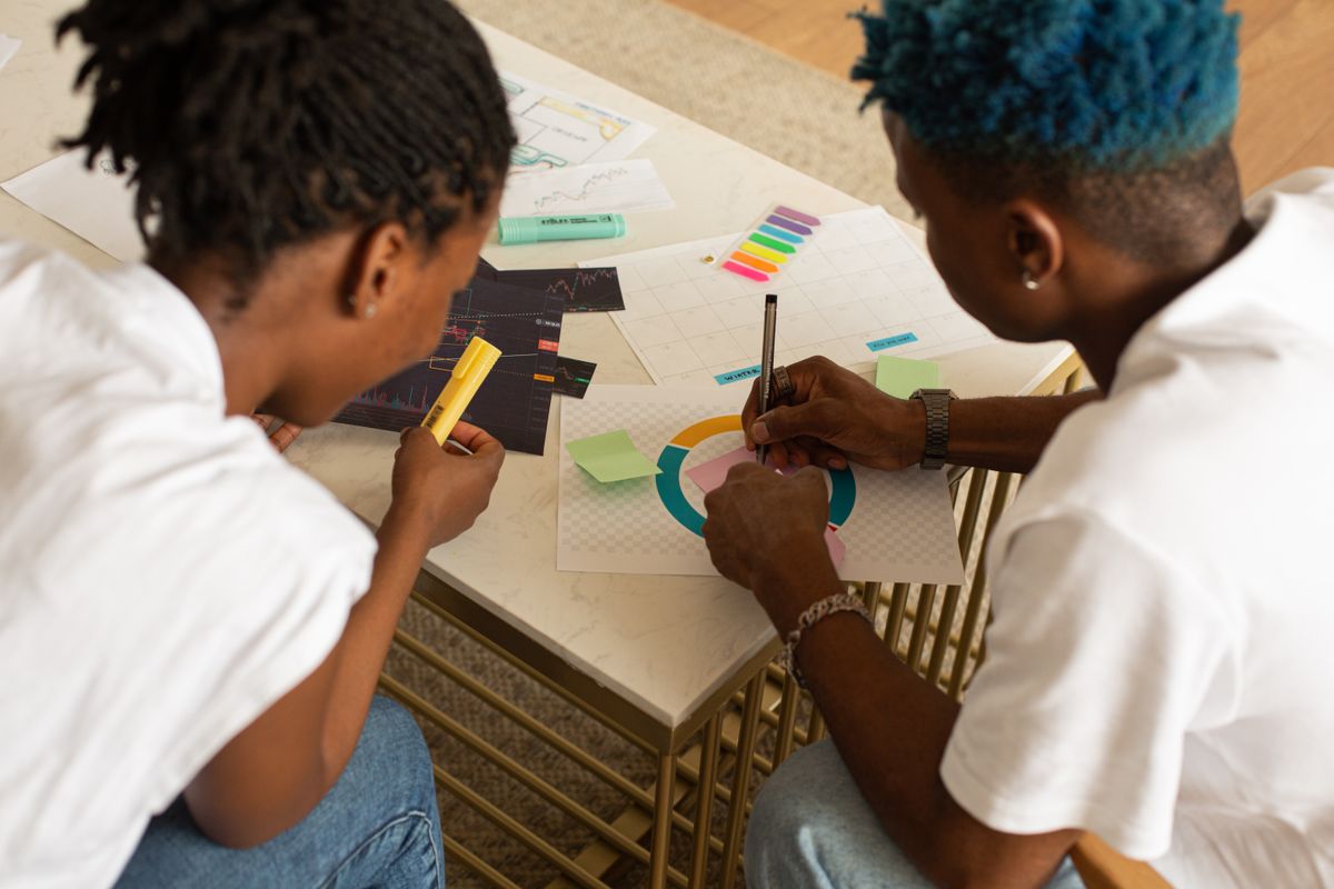 Two designers reviewing a storyboard printout together at a desk