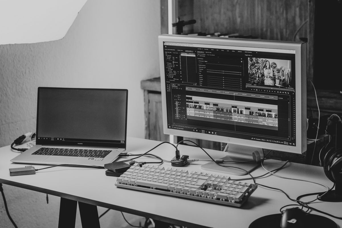 A laptop on a desk showing a video editing timeline
