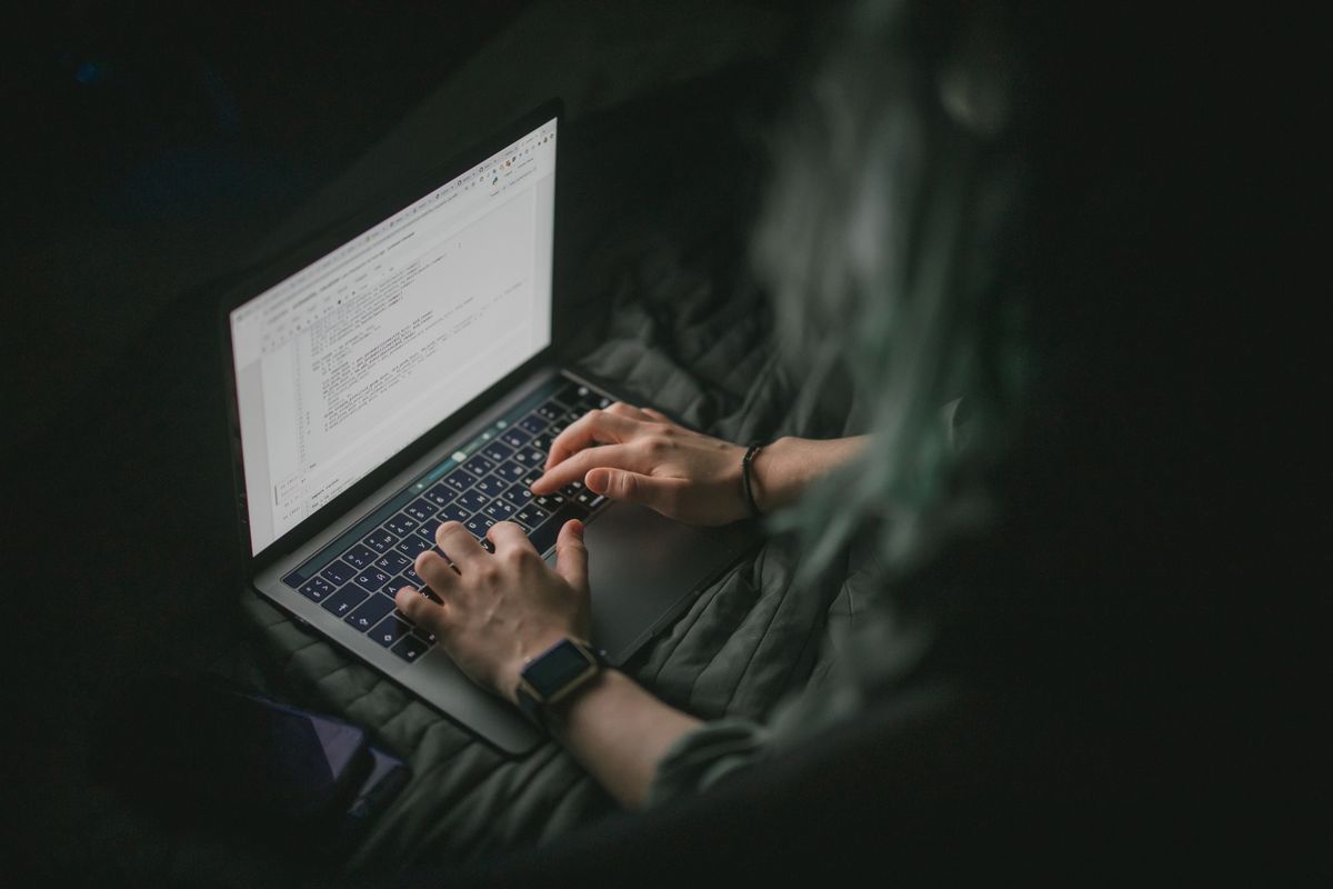 A developer's laptop showing code in a dark room
