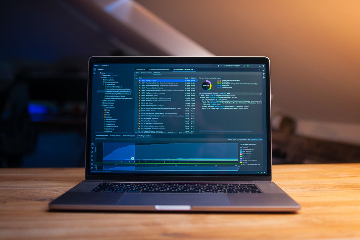 A laptop open on a wooden desk at night, a developer tool filling the screen
