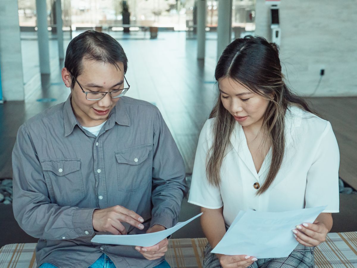 Two colleagues going through printed notes together at a table