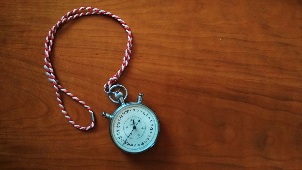 A stopwatch resting on a wooden desk