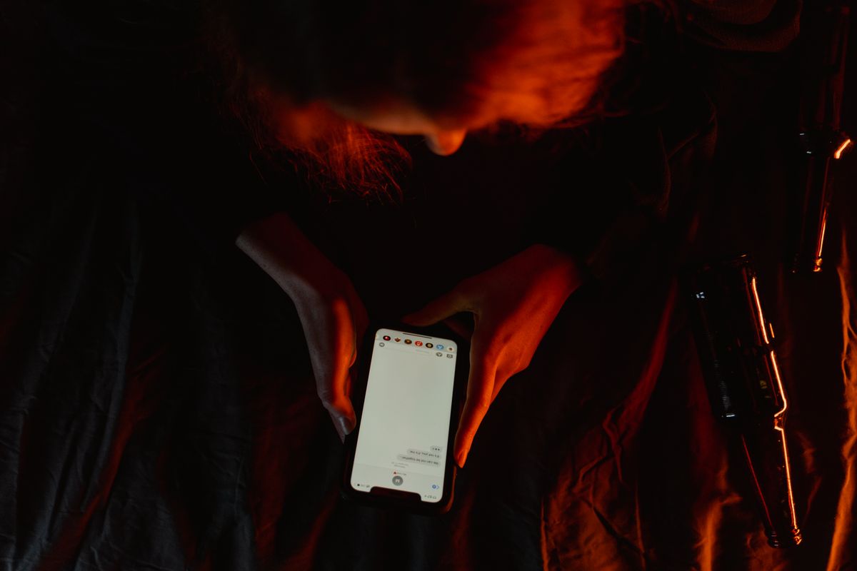 Someone testing a phone one-handed in a dim room late at night