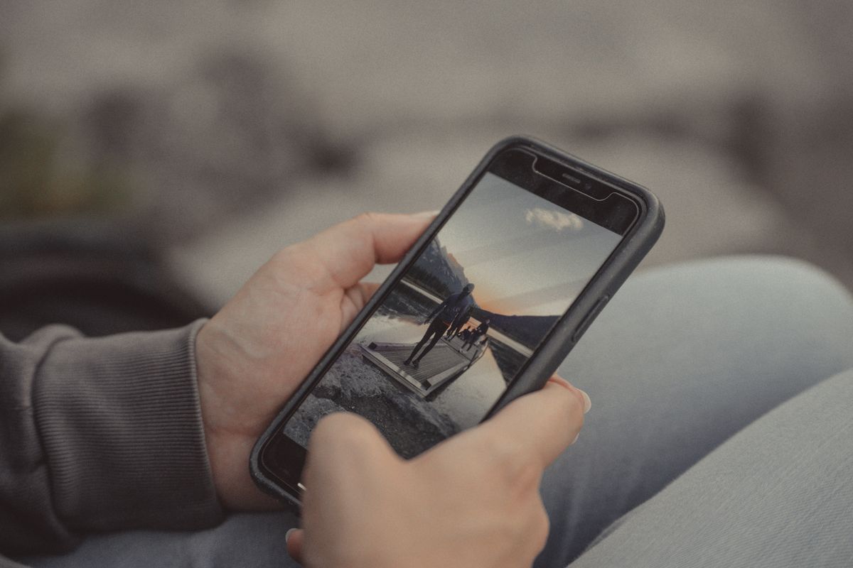 A person watching a video on a phone held at arm's length