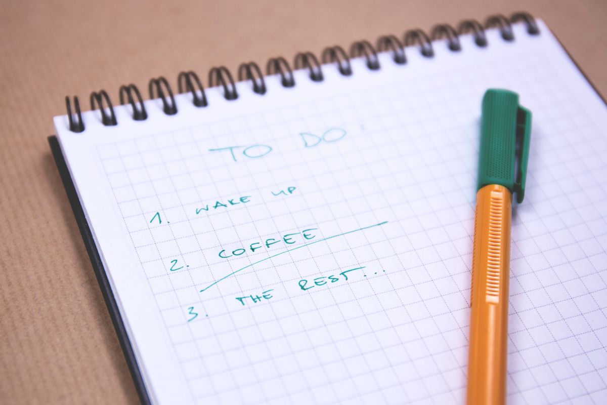 A handwritten checklist in an open notebook with a pen resting on it